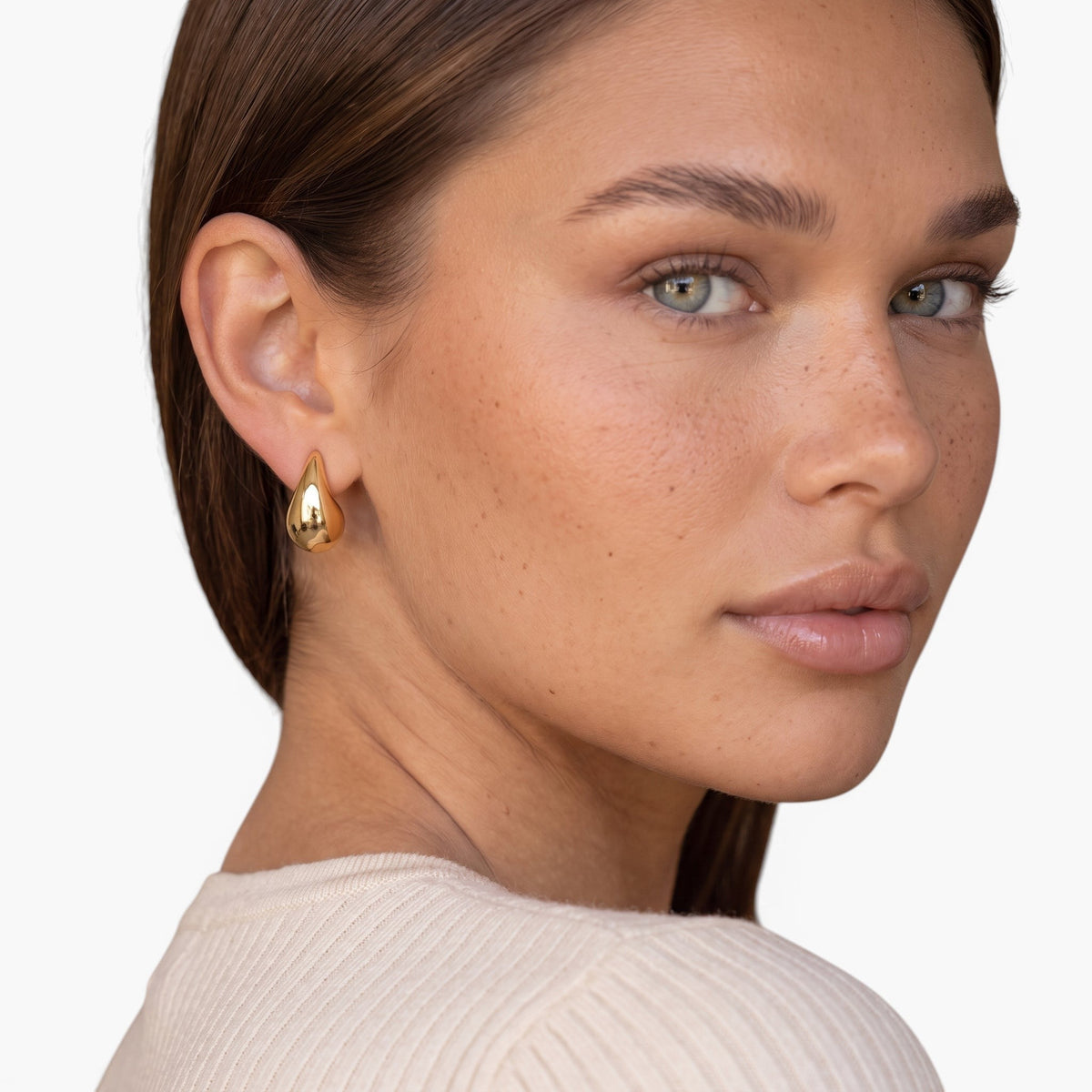 Evervanta gold teardrop earrings worn by a woman with a polished finish and raindrop shape.