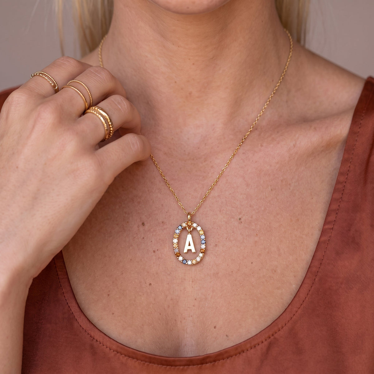 Collier pendentif initiale doré avec pierre colorée