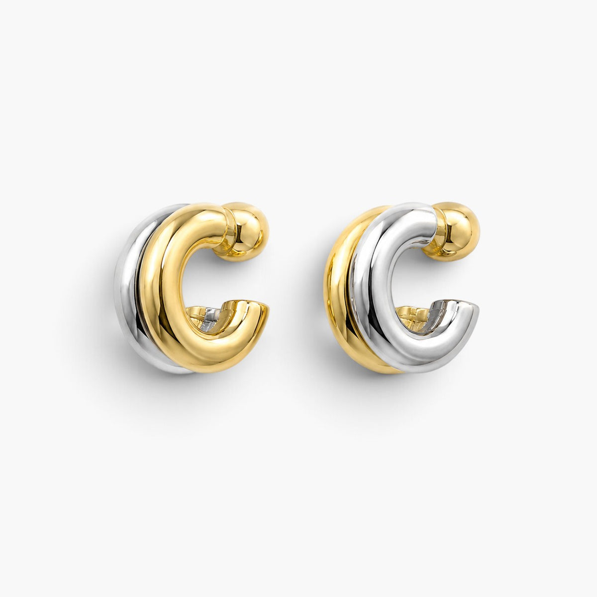 Evervanta two-tone huggie hoop earrings featuring a polished 18K gold and silver plated finish.